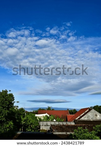 Beautiful cloudy blue sky high resolution background with houses roof at bottom foreground
