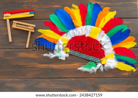 Indian headdress roach, wooden noisemakers for Jewish holiday Purim, for kid's holiday party on wooden background.