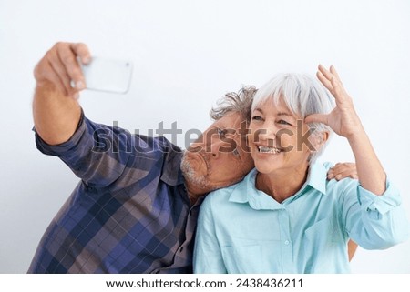 Old couple, funny face in selfie and happy together for social media post, memory and love with fun on white background. Crazy, silly or goofy with people in marriage, smile in picture and mobile app