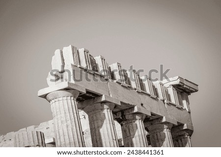 Black and white picture of the details figures sculptures columns of the Acropolis of Athens with amazing and beautiful ruins Parthenon and blue cloudy sky in Greece's capital Athens in Greece.