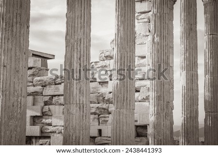 Black and white picture of the details figures sculptures columns of the Acropolis of Athens with amazing and beautiful ruins Parthenon and blue cloudy sky in Greece's capital Athens in Greece.