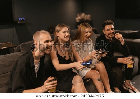 Women battle out on screen with men watching in game room. Laughter and banter flow freely among competitors enhancing friendship