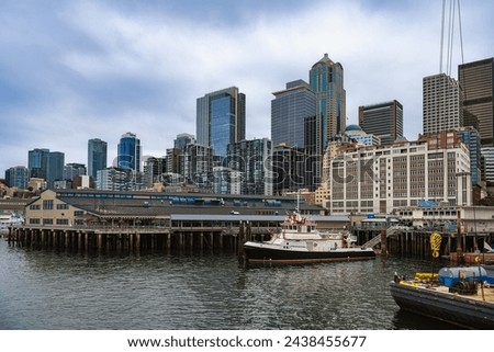 THE SEATTLE SKYLINE AND WATERFTONT BY PIER 54 WITH ELLIOTT BAY AND A CLOUDY SKY