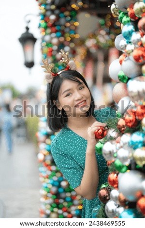 Portrait of Asian Thai woman posing in Christmas village with shops. Event holiday. Peope lifestyle