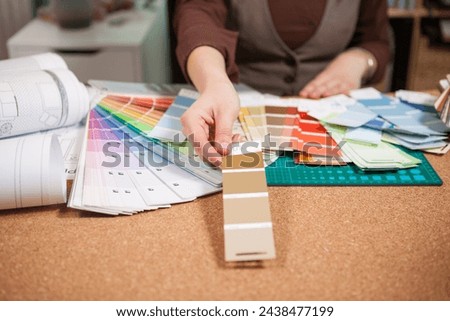 Architect choosing from different colors on the cards in front of her. Architecture and construction. Color pallete