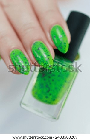 Female hand with long nails and neon green manicure