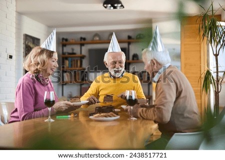 Group of cheerful senior friends having fun during a Birthday party at home