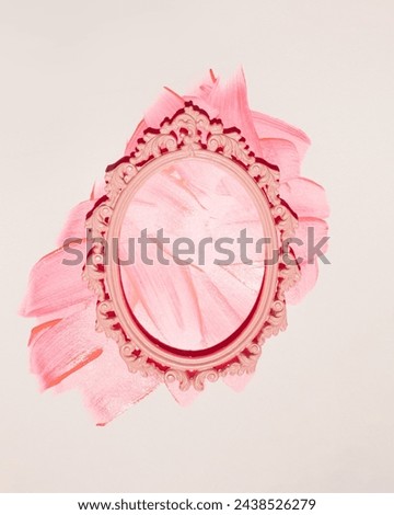 Careless strokes of pink paint on the wall, oval picture frame, creative wall decoration with copy space.