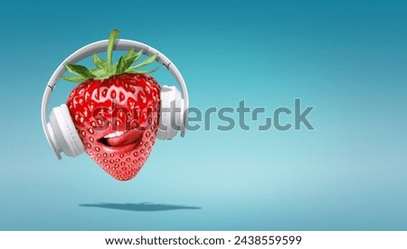 Summer minimalist pop art photography made with  strawberry wearing headphones and listening to music.Minimal concept summer and party.Celebrating the summer vibes.Creative art.Contemporary style.