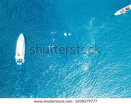 Drone photos of snorkelers swimming in the open ocean in search of manta rays near their boats
