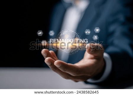 Remarketing concept. Reaching the target audience that has previously visited the website through advertising. Businessman holding globe with remarketing icon on virtual screen.