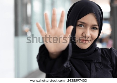 Smiling Muslim Woman showing stop or halt hand Gesture, concept image of No way, unaccepting, wrong, rejection, no, bad, deny, refuse, disagree, dislike, Unhappy and Negative expression
