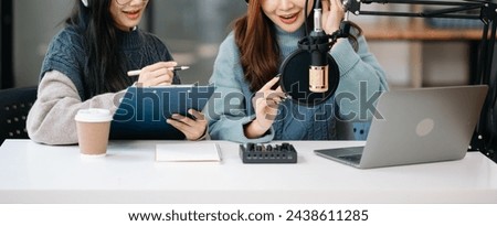 Young woman and woman wearing headphones and doing a live podcast for their channel, communication for radio podcast and technology concept
