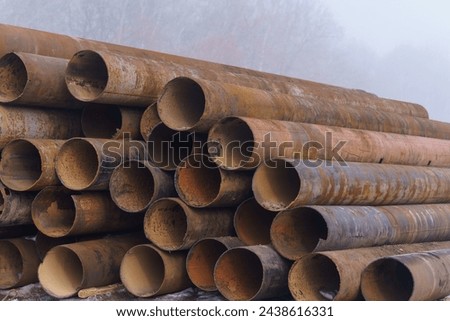 The photograph depicts large steel pipes, once in use. These imposing industrial structures bear the marks of their past, with traces of rust and weathering indicating years of service. 