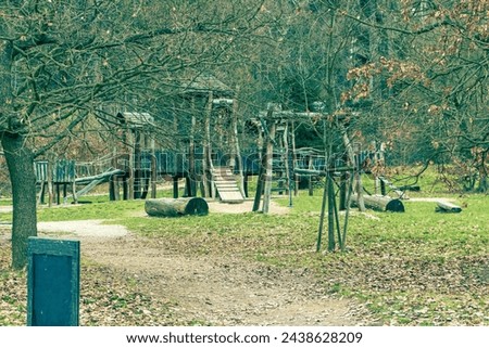 Abstract photo of an abandoned wooden playground in cold winter weather. Abandoned playground, wooden playground in nature, forest, trees, nature, children's playground