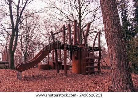 Abstract photo of an abandoned wooden playground in cold winter weather. Abandoned playground, wooden playground in nature, forest, trees, nature, children's playground