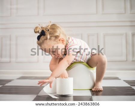 funny child girl sitting on chamberpot Royalty-Free Stock Photo #243863806