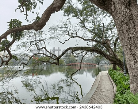 Hanoi's Pedestrian Street, the view of Hoan Kiem Lake (Lake of the Returned Sword) and The Huc Bridge (Morning Sunlight Bridge). Royalty-Free Stock Photo #2438642403