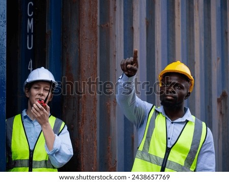 people person human male man female woman yellow orange hardhat helmet safety young adult work job pointing finger cheerful black skin south african american talkie walkie radio import export outdoor