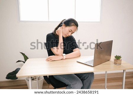Young Female Student Suffering Neck Pain While Working on Laptop  Royalty-Free Stock Photo #2438658191
