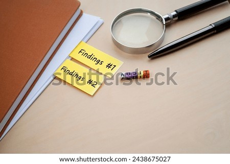 Audit and Findings concept. The word AUDIT on colorful cubes, and  Findings on the yellow tabs. A pen and eyeglasses at the back