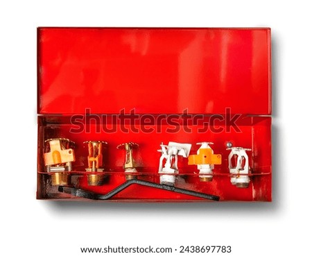 Wet fire sprinkler head replacement cabinet. 6 sprinkler heads with wrench in box. Assortiment of fire sprinkler heads for underground parking sprinkler system. Selective focus. White background.  Royalty-Free Stock Photo #2438697783