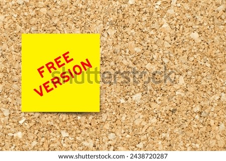 Yellow note paper with word free version on cork board background with copy space