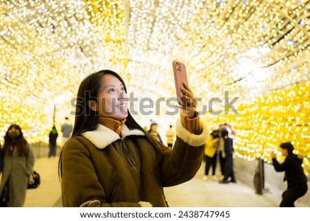 Woman take selfie on cellphone in city at night