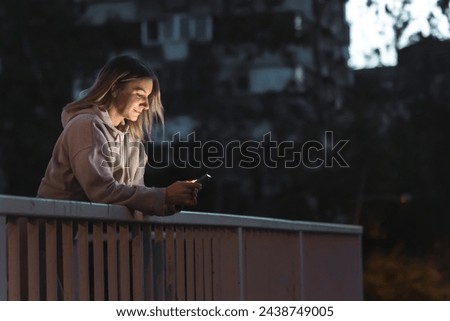 Active young woman using smart phone before jogging at dawn before sunrise early in the morning