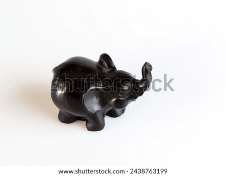 A figurine of a black elephant on a white background.