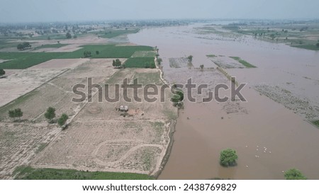 Floods, agricultural land, green crops, trees, villages, blue skies 