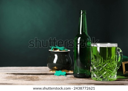 St. Patrick's day party. Green beer, leprechaun hat, pot of gold and decorative clover leaves on wooden table. Space for text