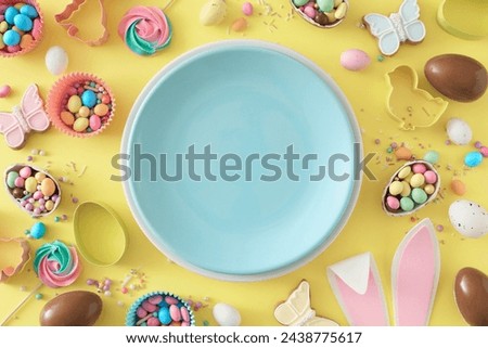 Easter celebration idea. Top view photo of empty circle plate rabbit bunny ears chocolate eggs easter candy and baking molds on isolated yellow background with blank space