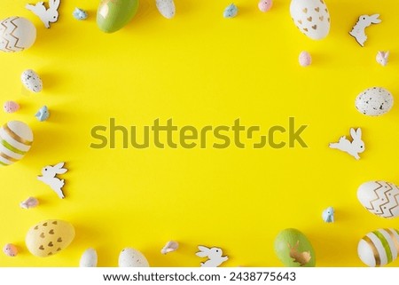 Easter decorations concept. Top view photo of color eggs and cute easter bunnies on yellow background with copyspace in the middle. Holiday invitation card idea.