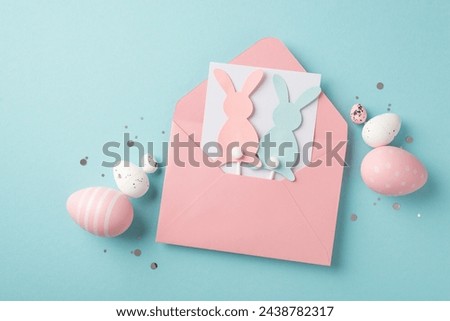 Top view photo of easter decorations open pink envelope with letter and two easter bunny silhouettes sequins pink and white easter eggs on isolated pastel blue background