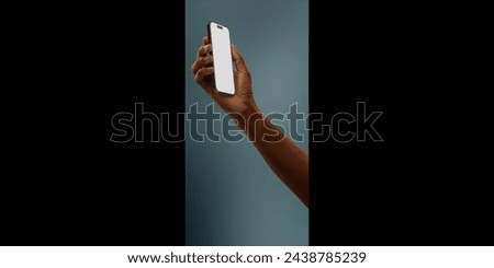 Black African-American hand displays a modern smartphone with a blank screen against a deep teal background, ideal for presenting apps or mobile interfaces in a clean and contemporary setting Royalty-Free Stock Photo #2438785239