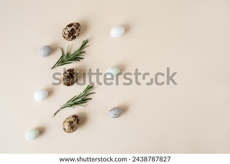 Quail eggs and rosemary sprigs on a beige background. Easter background, space for text, top view