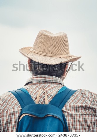 Back view picture of a man wearing a elegant sun hat.
