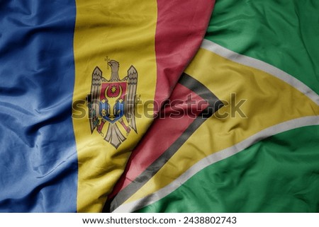big waving national colorful flag of guyana and national flag of moldova . macro