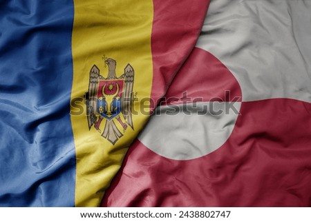 big waving national colorful flag of greenland and national flag of moldova . macro