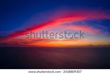 panoramic aerial of dramatic red and orange sunset over the ocean on grace bay beach, Turks and Caicos captured with drone Royalty-Free Stock Photo #2438809307