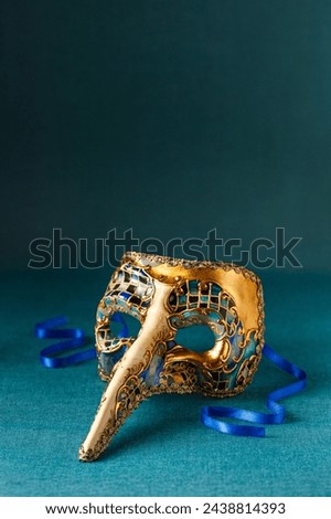 Beautiful multicolor carnival mask on a blue background. Purim, Mardi Gras holiday concept. Vertical Banner