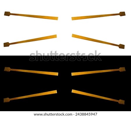 Small wooden oars for a boat in rowing position on isolated white and black background