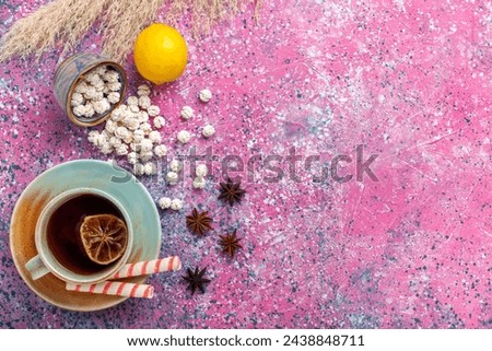 top view cup of tea with white sweet confitures and lemon on the pink background candy sugar sweet tea color bonbon Royalty-Free Stock Photo #2438848711