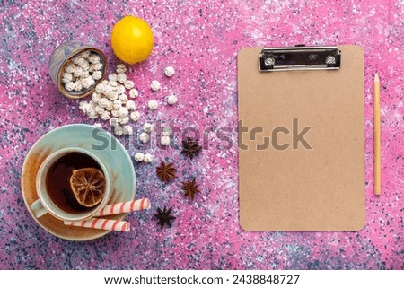 top view cup of tea with white sweet confitures and lemon on the pink desk candy sugar sweet tea color bonbon Royalty-Free Stock Photo #2438848727