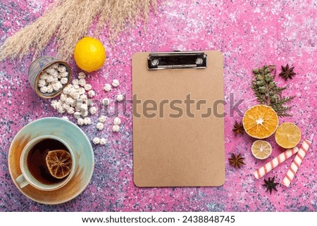 top view cup of tea with white sweet confitures and fresh lemon on pink background candy sugar sweet tea color bonbon Royalty-Free Stock Photo #2438848745