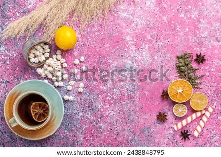 top view cup of tea with lemon and white sweet confitures on pink background candy sugar sweet tea color bonbon Royalty-Free Stock Photo #2438848795