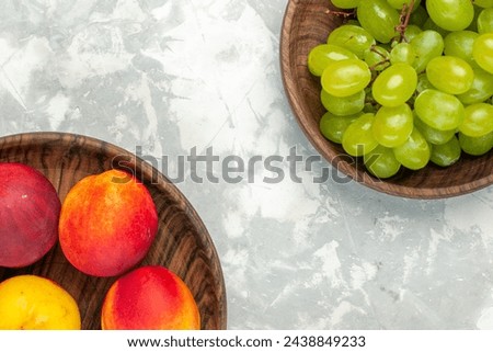 top view fresh green grapes mellow and delicious with peaches on light white desk fruit fresh mellow tropical Royalty-Free Stock Photo #2438849233