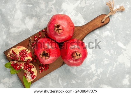top view fresh red pomegranates sour and mellow fruits on light-white desk fruit fresh mellow ripe tree Royalty-Free Stock Photo #2438849379