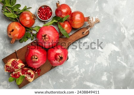 top view fresh red pomegranates sour and mellow fruits on the light-white desk fruit fresh mellow ripe tree Royalty-Free Stock Photo #2438849411